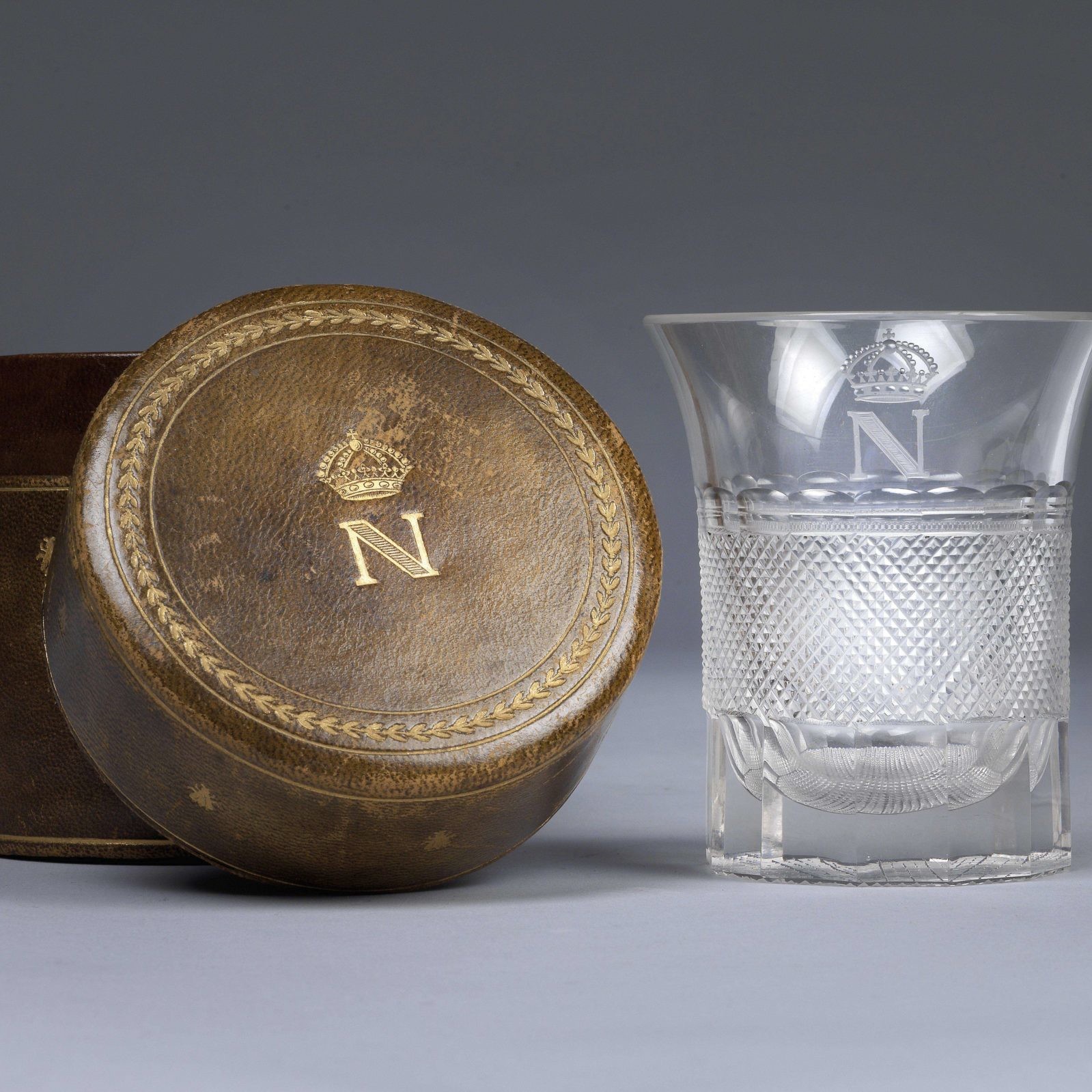 Glass with cut decoration and gilded monogram with crowned N, which belonged to the Emperor Napoleon I. Monogrammed leather case © Dorotheum