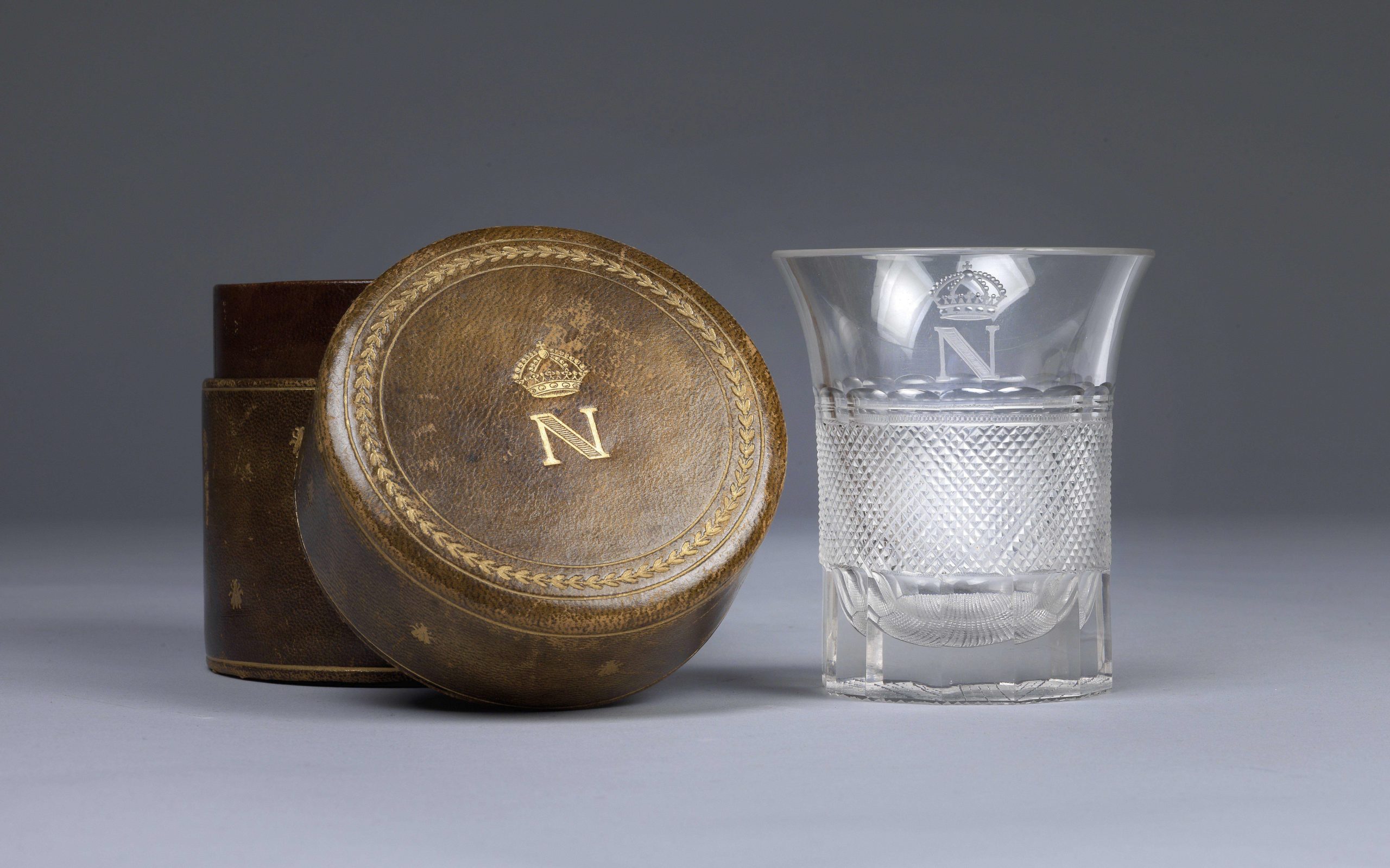 Verre à décor taillé et monogramme doré au N couronné ayant appartenu à l'empereur Napoléon Ier. Étui en cuir monogrammé © Dorotheum